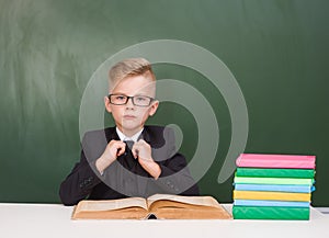 Serious schoolboy in a suit in classroom