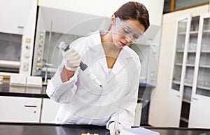 Serious scientist pouring a liquid