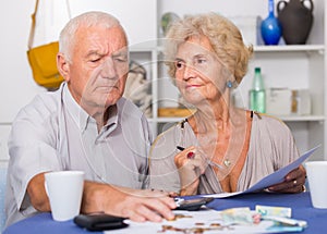 Serious senior couple counting bills