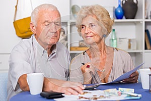 Serious senior couple counting bills