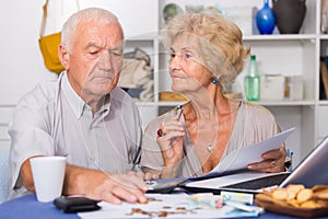 Serious senior couple counting bills