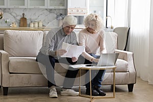 Serious senior retired couple counting domestic budget