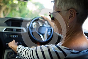 Serious senior woman driving car