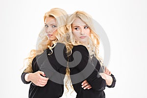 Serious sisters twins with arms folded