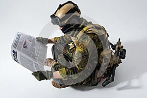 Serious soldier looking through article