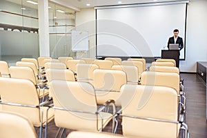 Serious speaker using laptop in empty boardroom