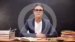 Serious and strict female teacher looking to camera, education reform occupation