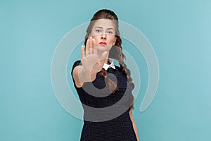 Serious strict woman standing and looking at camera, showing palm stop gestured, protect herself. photo