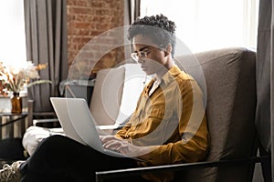 Serious student, homeowner woman, freelance employee working at laptop