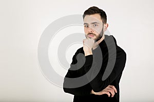 Serious stylish attractive young man with a small beard in black