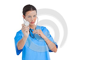 Serious surgeon holding up stethoscope