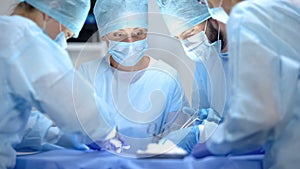 Serious surgeon team performing cardiothoracic surgery, hospital operation