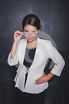 Serious teacher looking at you on blackboard