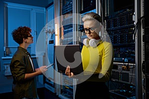 Serious technicians working together with network hardware