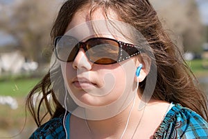 Serious teen with earbuds listening to music