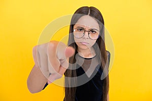 Serious teen girl wearing glasses because of bad eyesight and pointing finger on camera, selective focus, mood