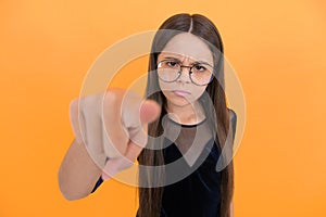 serious teen girl wearing glasses because of bad eyesight and pointing finger on camera, selective focus, mood