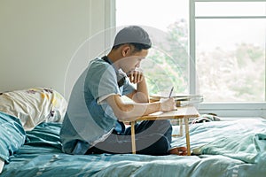 Serious teenage asian boy study at home