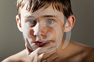 Serious Teenage Boy with Hand Resting on Chin