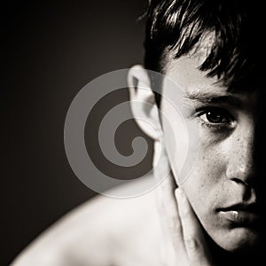 Serious Teenage Boy with Hand Resting on Neck