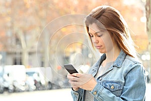 Serious teenage girl chatting on phone in the street