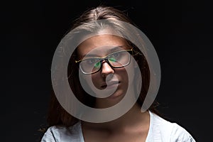 Serious teenager girl in shadow with glasses