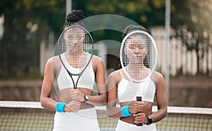 Serious tennis players holding their rackets. Portrait of young tennis players covering their faces with rackets on the
