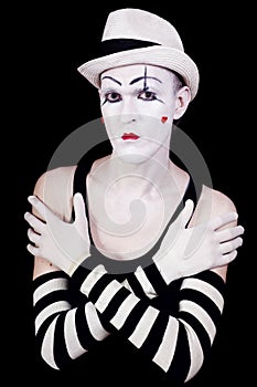 Serious theatrical clown in white hat