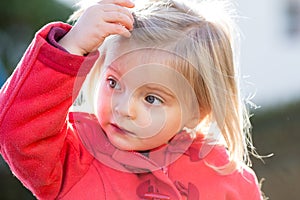 Serious thinking or sad young baby caucasian blonde real people girl close portrait outdoor