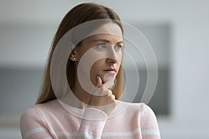 Serious thoughtful 30s woman in casual standing indoors