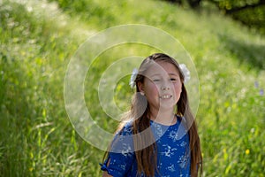 Serious and Thoughtful Little Girl in Blue Dress in front of golden field at Park