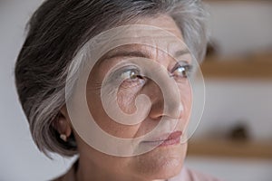 Serious thoughtful senior mature woman looking away in deep thought