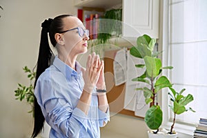 Serious thoughtful woman in her 30s looking out the window