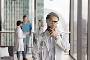 Serious thoughtful young head doctor man looking at camera