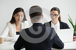 Serious unconvinced diverse hr managers interviewing male job ap