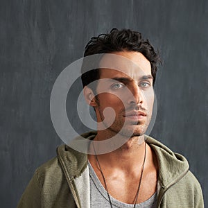 Serious, upset and portrait of man by a wall with disappointed, angry or moody facial expression. Frown, confused and