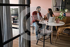 Serious wife and husband planning budget, checking finances, focused young woman using online calculator and counting