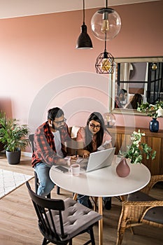 Serious wife and husband planning budget, checking finances, focused young woman using online calculator and counting