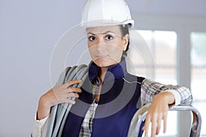 serious woman builder holding cables
