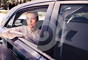 Serious woman in car. Sad, upset or tired taxi passenger. Cool elegant business lady sitting on the back seat looking out.