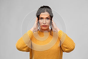 Serious woman closing ears with hands