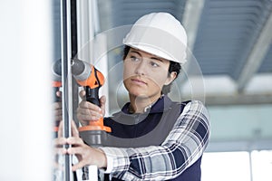 serious woman drilling window
