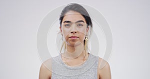 Serious woman, face and blank stare standing isolated against a studio background. Portrait of attractive caucasian