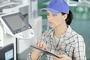serious woman fixing printer