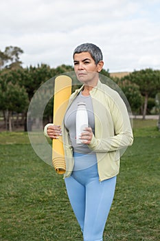 Serious woman with grey hair after training in park