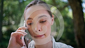 Serious woman have phone conversation in park close up. Girl talking smartphone