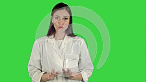 Serious woman in lab coat talking to the camera on a Green Screen, Chroma Key