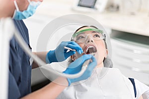 Serious woman making treatment in odontology