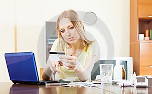 Serious woman paying medications in internet store