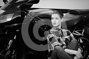 Serious woman in a shirt on a motorcycle background, smoothed hair, black and white